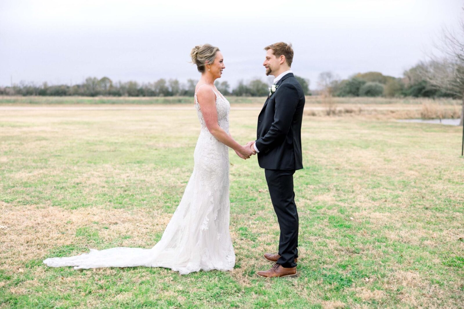 A bride and groom holding hands after seeing one another