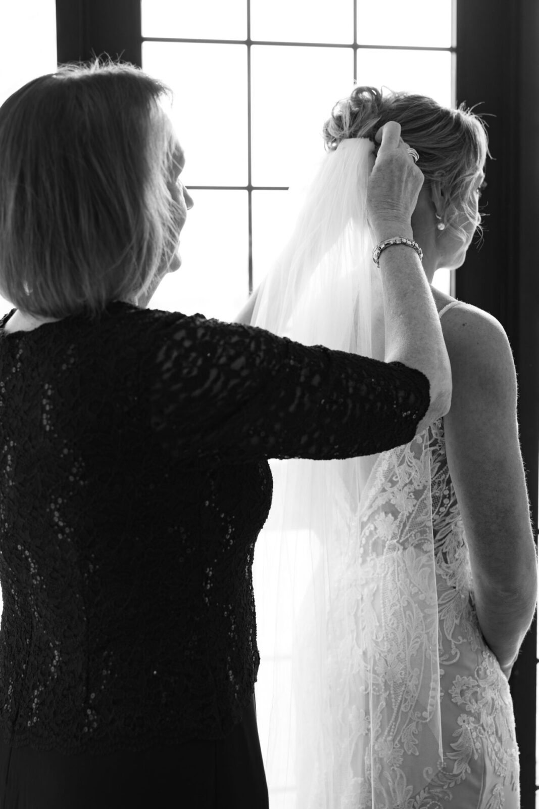 Mother putting veil in a bride's hair.