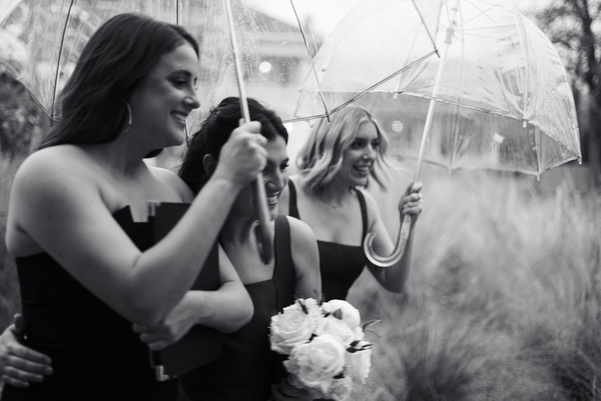 Bridesmaids running through the rainy weather
